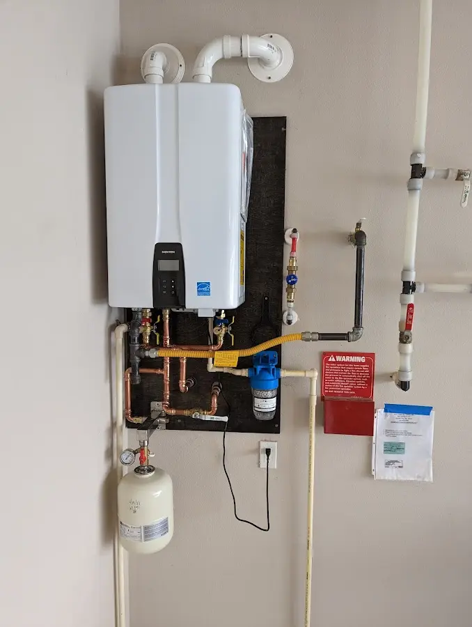 Professional plumber installing copper piping in a Willington home